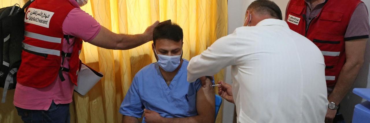 Das Foto zeigt, wie eine Gesundheitsfachkraft in Idlib/Syrien mit Astrazeneca geimpft wird. Das Foto zeigt, wie eine Gesundheitsfachkraft in Idlib/Syrien mit Astrazeneca geimpft wird.