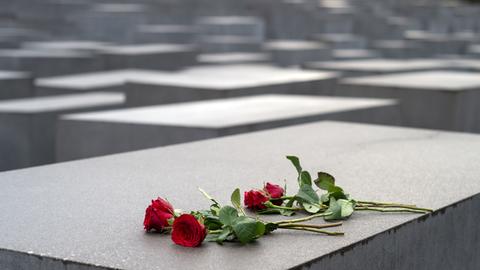 Rote Rosen liegen am 27.01.2015 auf einem Stein des Holocaust-Mahnmals in Berlin. Am 27.1.1945 befreite die Sowjetarmee das NS-Vernichtungslager Auschwitz.