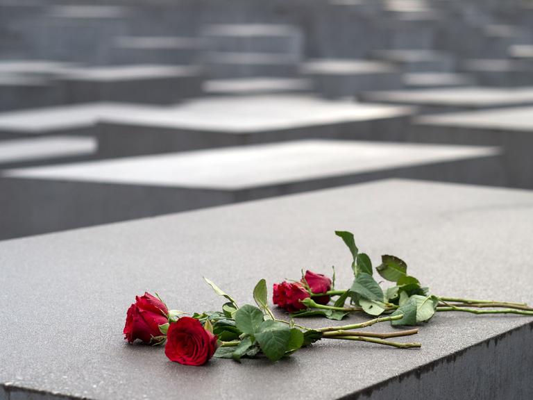Rote Rosen liegen am 27.01.2015 auf einem Stein des Holocaust-Mahnmals in Berlin. Am 27.1.1945 befreite die Sowjetarmee das NS-Vernichtungslager Auschwitz.