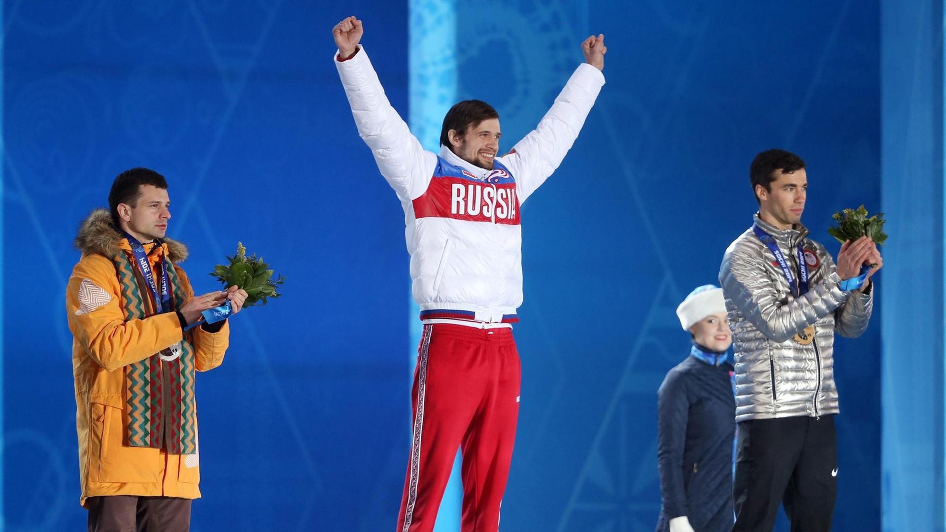 Alexander Tretiakov (Mitte) aus Russland jubelt bei den Olympischen Winterspielen in Sotschi 2014 über Gold im Skeleton. Der Lette Martins Dukurs (li.) muss mit Silber Vorlieb nehmen.