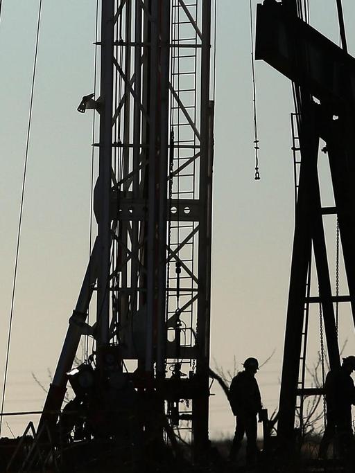 Ein Arbeiter steht vor Bohrtürmen einer Ölfirma in Odessa, im US-Bundesstaat Texas.