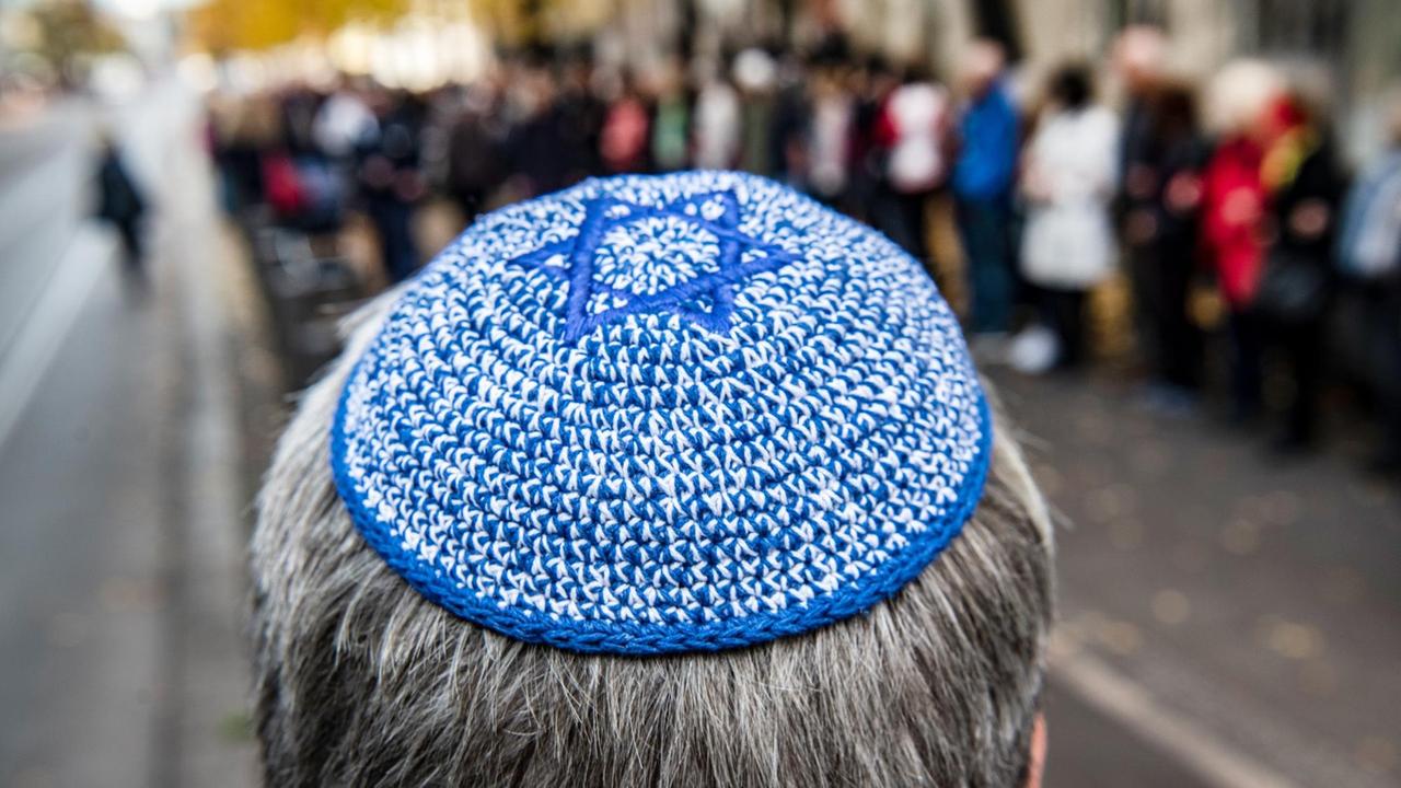 Ein Mann mit Kippa steht vor der Neuen Synagoge vor einer Menschenkette...</p>

                        <a href=