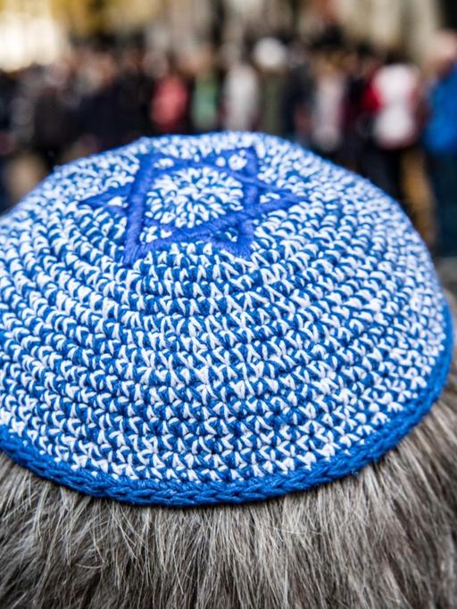 Ein Mann mit Kippa steht vor der Neuen Synagoge vor einer Menschenkette. Das Bündnis für ein weltoffenes und tolerantes Berlin hatte zu der Aktion unter dem Motto «Wir stehen an Eurer Seite!» aufgerufen, um ein Zeichen gegen Antisemitismus und Hass zu setzen.
