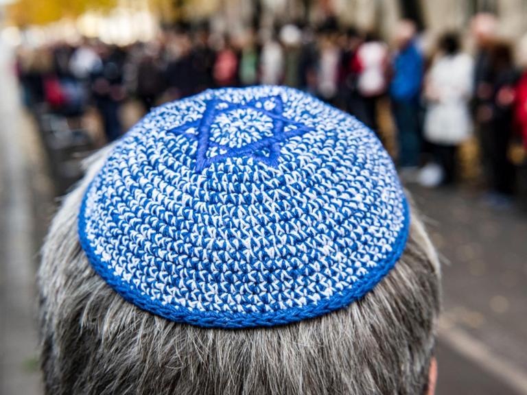 Ein Mann mit Kippa steht vor der Neuen Synagoge vor einer Menschenkette. Das Bündnis für ein weltoffenes und tolerantes Berlin hatte zu der Aktion unter dem Motto «Wir stehen an Eurer Seite!» aufgerufen, um ein Zeichen gegen Antisemitismus und Hass zu setzen.