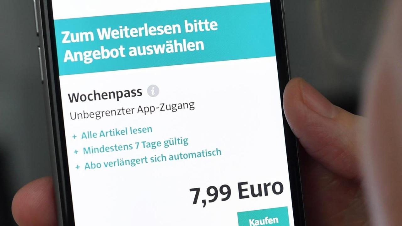Eine Frau hält am ein Smartphone in der Hand, mit dem sie das Internet-Portal der Süddeutschen Zeitung aufgerufen hat. Eine Frau hält am ein Smartphone in der Hand, mit dem sie das Internet-Portal der Süddeutschen Zeitung aufgerufen hat.