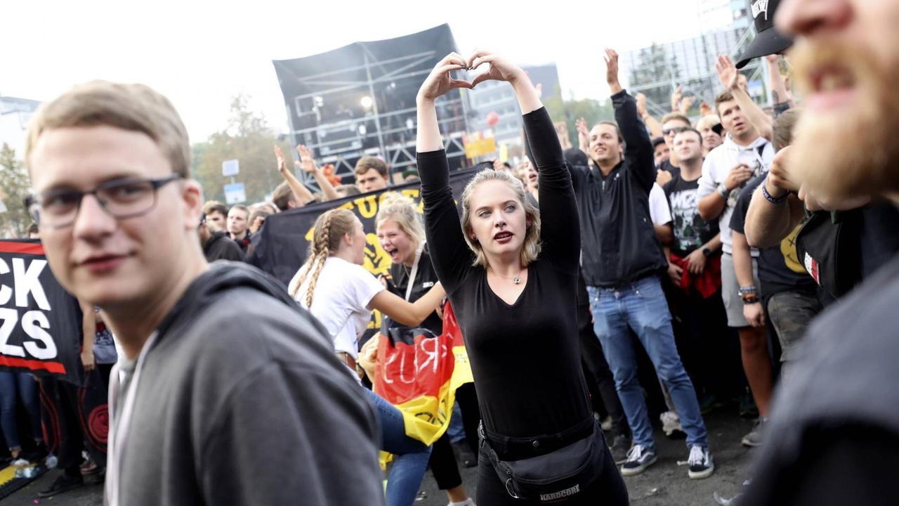 Eine junge Frau formt mit ihren Händen ein Herz über ihrem Kopf auf dem #wirsindmehr-Festival in Chemnitz. Eine junge Frau formt mit ihren Händen ein Herz über ihrem Kopf auf dem #wirsindmehr-Festival in Chemnitz.