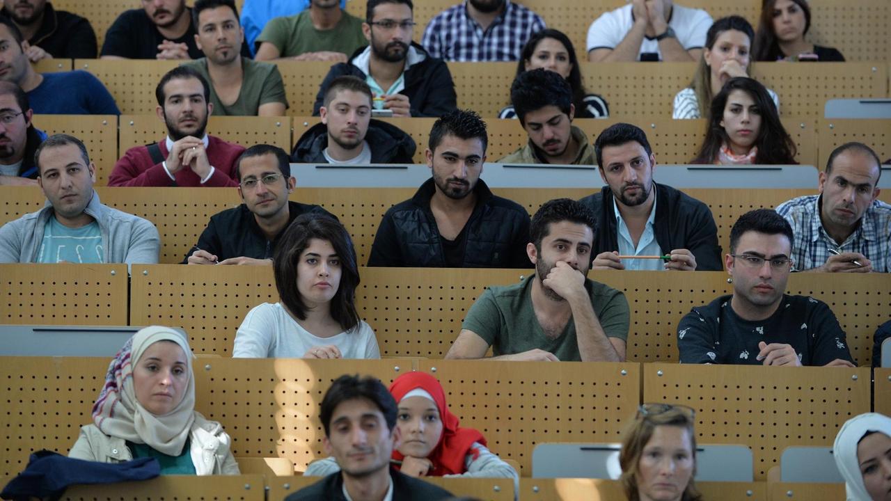Studentinnen und Studenten sitzen am 04.10.2016 in Bremen bei einer Einführungsveranstaltung der Universität in einem Hörsaal. Sie sind Flüchtlinge aus verschiedenen Ländern, vor allem aber aus Syrien. Alle haben einen akademischen Hintergrund und zuvor das Bewerbungsverfahren durchlaufen.