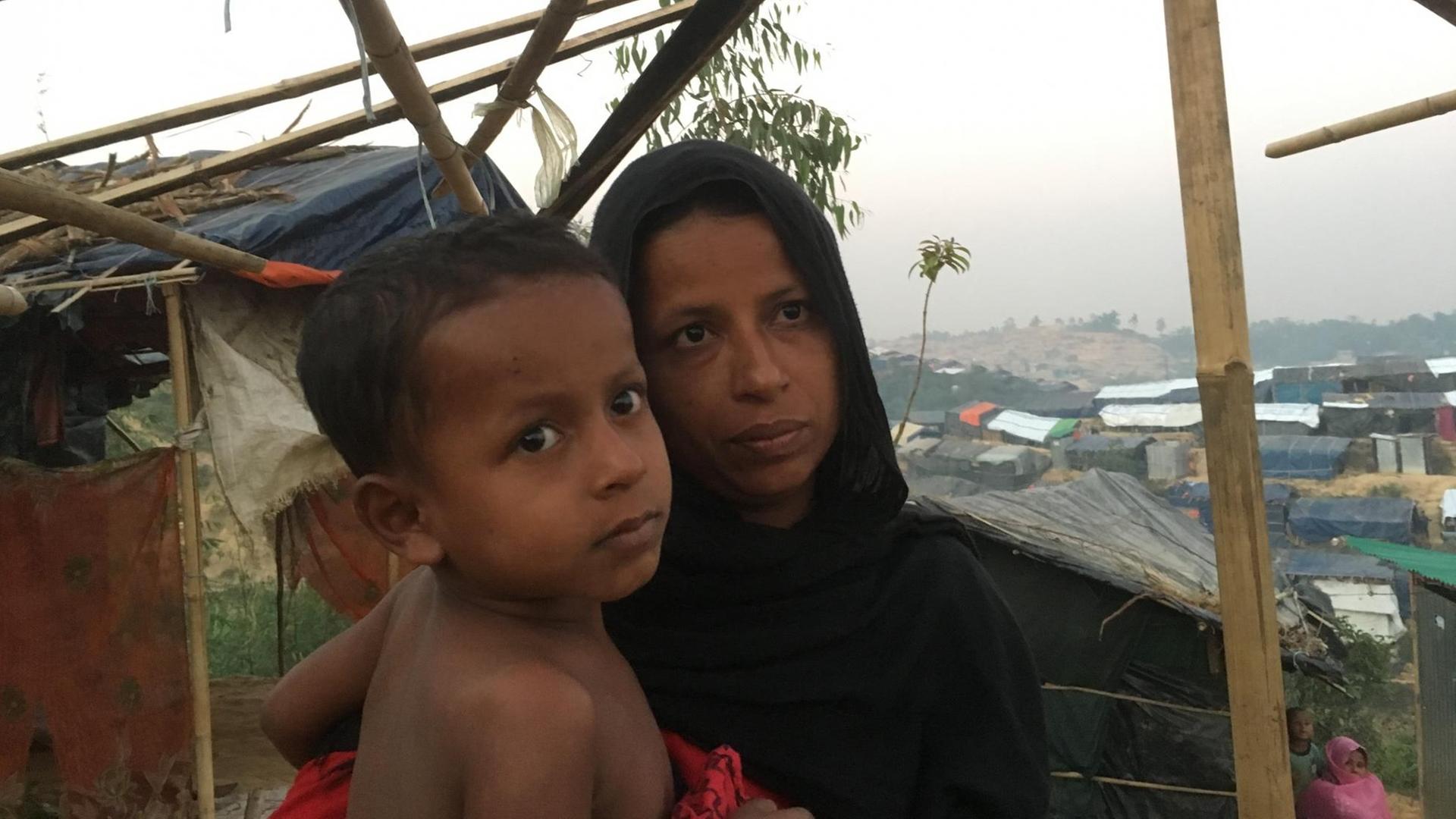 Rund 60 Flüchtlinge, Rohingya aus Myanmar, warten in dem Dörfchen Sabrang unter einem provisorischen Unterstand, unter ihnen viele Kinder und Frauen, ein paar junge Männer. Diese junge Frau ist mit ihren Kindern geflohen nachdem ir Ehemann ermordet wurde. Üerprüfen können wir ihre Geschichte nicht. Webermann, Dezember 2017 Rund 60 Flüchtlinge, Rohingya aus Myanmar, warten in dem Dörfchen Sabrang unter einem provisorischen Unterstand, unter ihnen viele Kinder und Frauen, ein paar junge Männer. Diese junge Frau ist mit ihren Kindern geflohen nachdem ir Ehemann ermordet wurde. Üerprüfen können wir ihre Geschichte nicht. Webermann, Dezember 2017