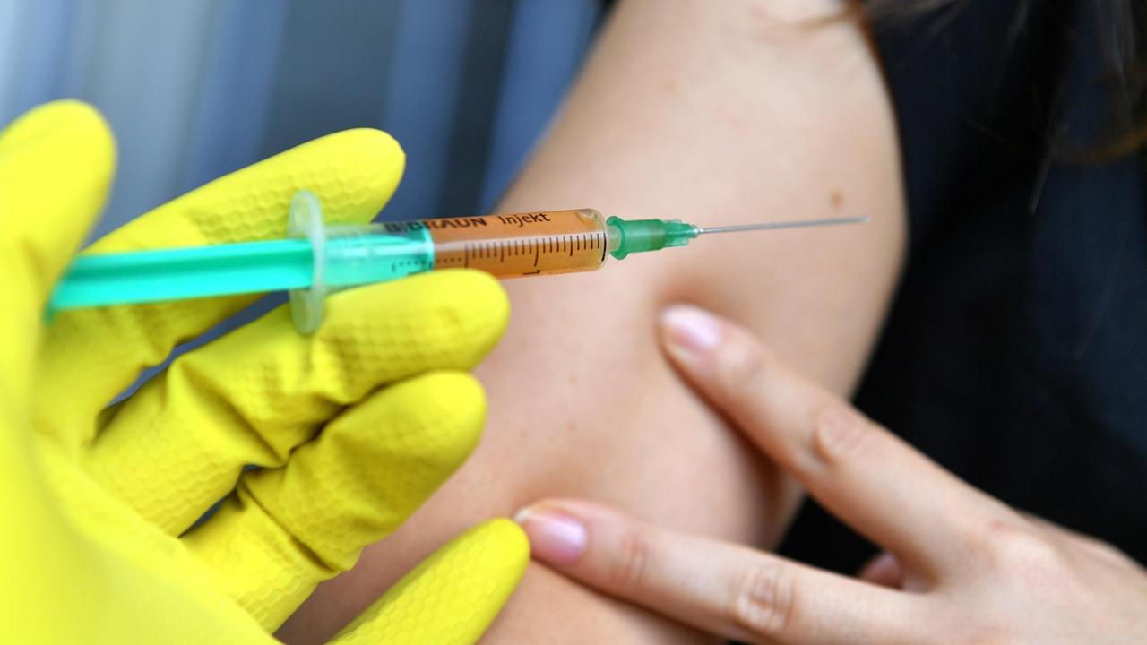 Eine Spritze vor einem Arm (Symbolbild) Eine Spritze vor einem Arm (Symbolbild)