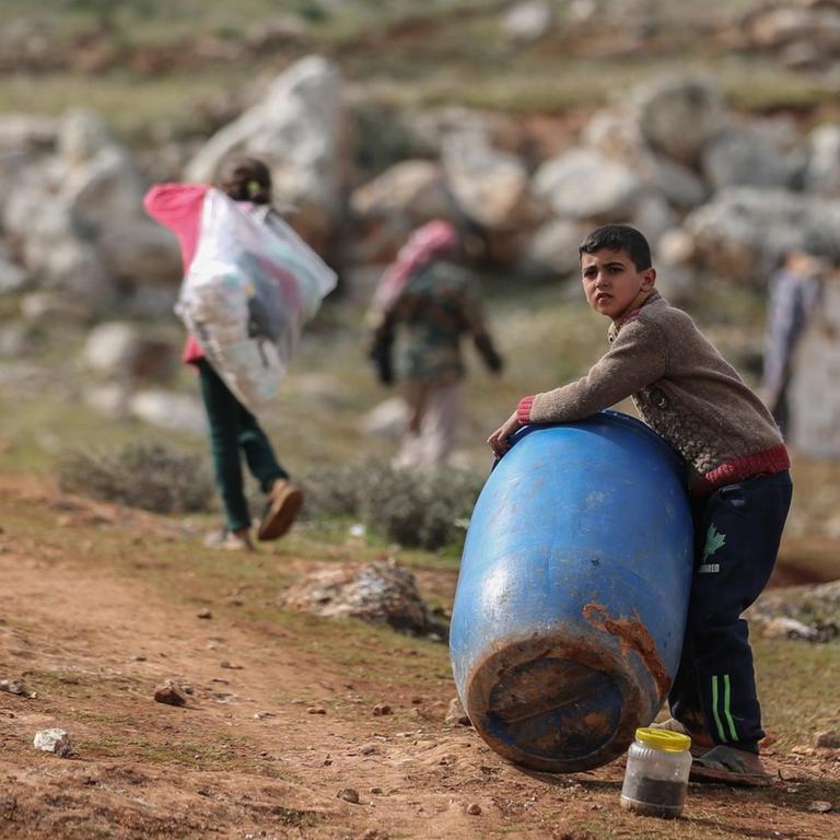 Ein syrischer Junge hält ein Plastikfass in der Nähe eines behelfsmäßigen Lagers für Familien, die infolge der Bombardierung und der Militäroperationen aus dem Idlib-Land vertrieben wurden. 