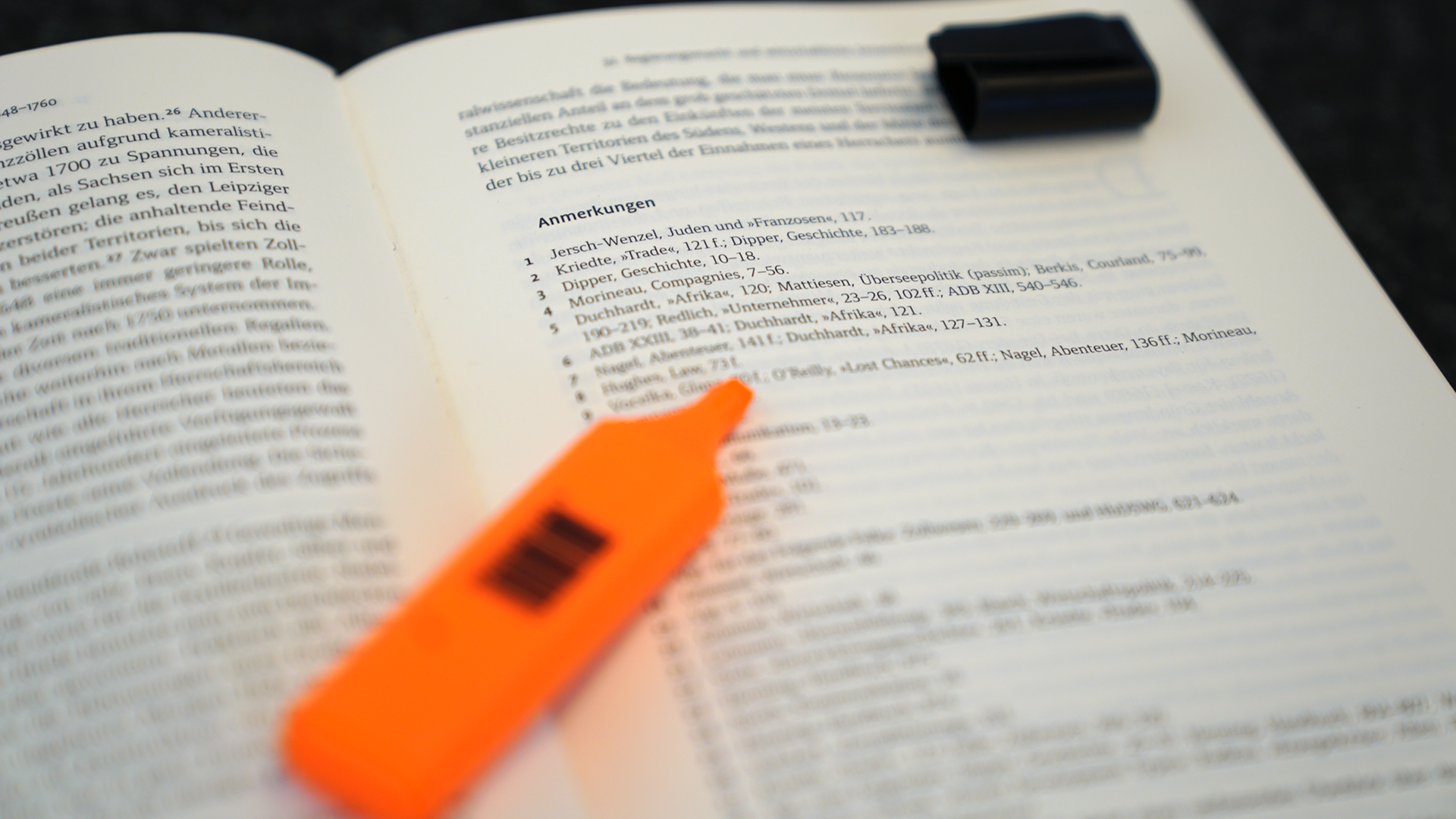 Anmerkungen und Fußnoten in einem aufgeschlagenen Fachbuch, auf dem ein Textmarker liegt Anmerkungen und Fußnoten in einem aufgeschlagenen Fachbuch, auf dem ein Textmarker liegt