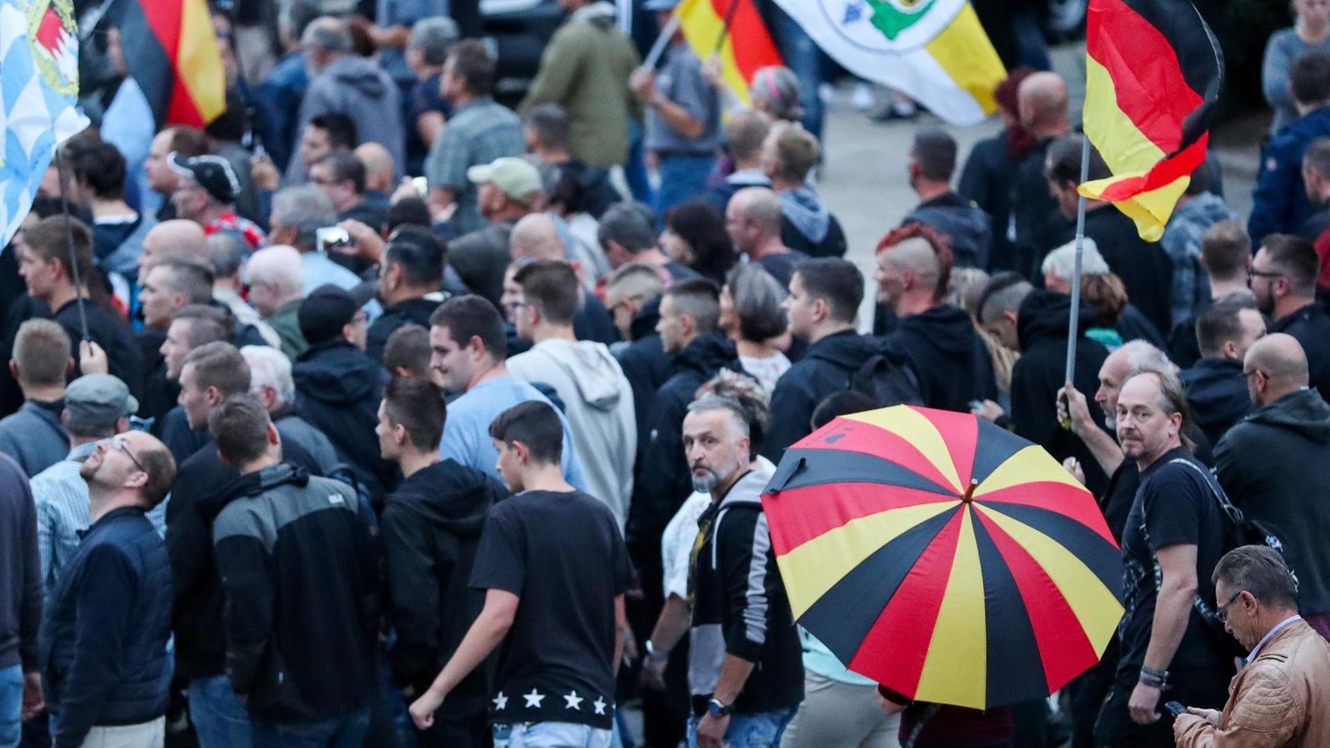 Demonstranten der rechten Szene bei einer Veranstaltung im August in Chemnitz mit Deutschland-Fahnen und Schirmen Demonstranten der rechten Szene bei einer Veranstaltung im August in Chemnitz mit Deutschland-Fahnen und Schirmen