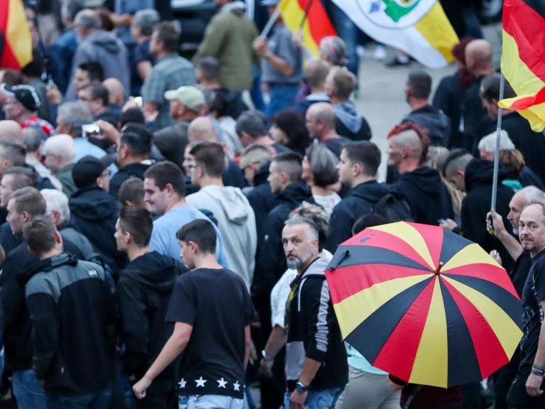 Demonstranten der rechten Szene bei einer Veranstaltung im August in Chemnitz mit Deutschland-Fahnen und Schirmen