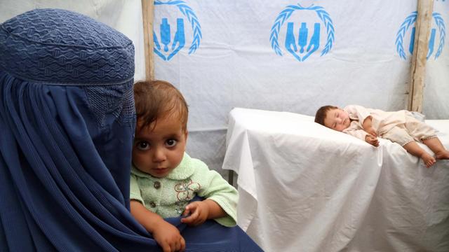 Afghanische Flüchtlinge, eine Mutter und ihre zwei Kinder in einem Medizinzelt des UNHCR.