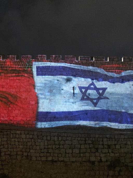 Die Nationalflaggen Israels und Marokkos werden, zusammen mit dem Wort "Frieden" auf Englisch, Hebräisch und Arabisch auf die Wände der Altstadt von Jerusalem projiziert.