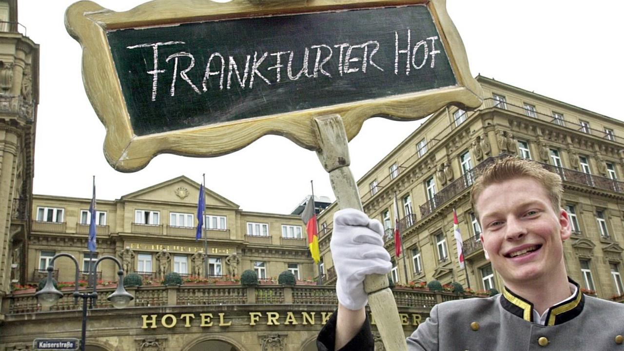 Ein Schild mit der Aufschrift "Frankfurter Hof" hält Hotelpage Alexander Vorderwisch am 21.5.2003 vor dem zur Steigenberger Hotels AG gehörendem Frankfurter Luxushotel hoch. Ein Schild mit der Aufschrift "Frankfurter Hof" hält Hotelpage Alexander Vorderwisch am 21.5.2003 vor dem zur Steigenberger Hotels AG gehörendem Frankfurter Luxushotel hoch.