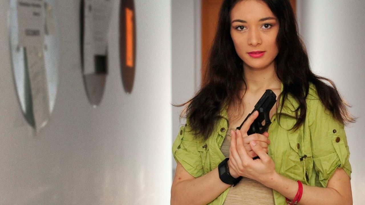 Carolin Matthie, Studentin, die in Youtube-Videos den Umgang mit Schreckschusswaffen erklärt. Fotografiert in einem Studentenwohnheim in Berlin-Adlershof. Die 24-Jährige Informatikstudentin hat sich eine Schreckschusspistole gekauft und schwärmt davon in Youtube-Videos. Sie hat sich für den Marktführer entschieden, die Walther P99. Die Waffe trägt sie in einem Halfter am Gürtel. Foto: Kai-Uwe Heinrich Carolin Matthie, Studentin, die in Youtube-Videos den Umgang mit Schreckschusswaffen erklärt. Fotografiert in einem Studentenwohnheim in Berlin-Adlershof. Die 24-Jährige Informatikstudentin hat sich eine Schreckschusspistole gekauft und schwärmt davon in Youtube-Videos. Sie hat sich für den Marktführer entschieden, die Walther P99. Die Waffe trägt sie in einem Halfter am Gürtel. Foto: Kai-Uwe Heinrich
