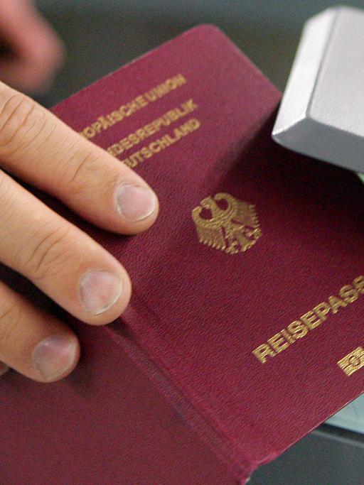Ein Mann hält am 16.10.2009 auf dem Flughafen in Frankfurt am Main seinen Reisepass in den Prototypen einer automatischen Passkontrolle, genannt "easy Pass".