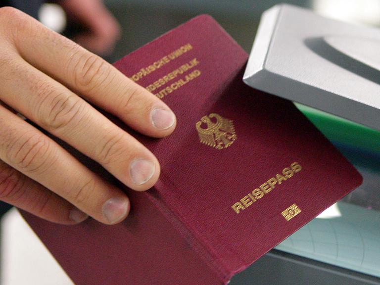 Ein Mann hält am 16.10.2009 auf dem Flughafen in Frankfurt am Main seinen Reisepass in den Prototypen einer automatischen Passkontrolle, genannt "easy Pass".
