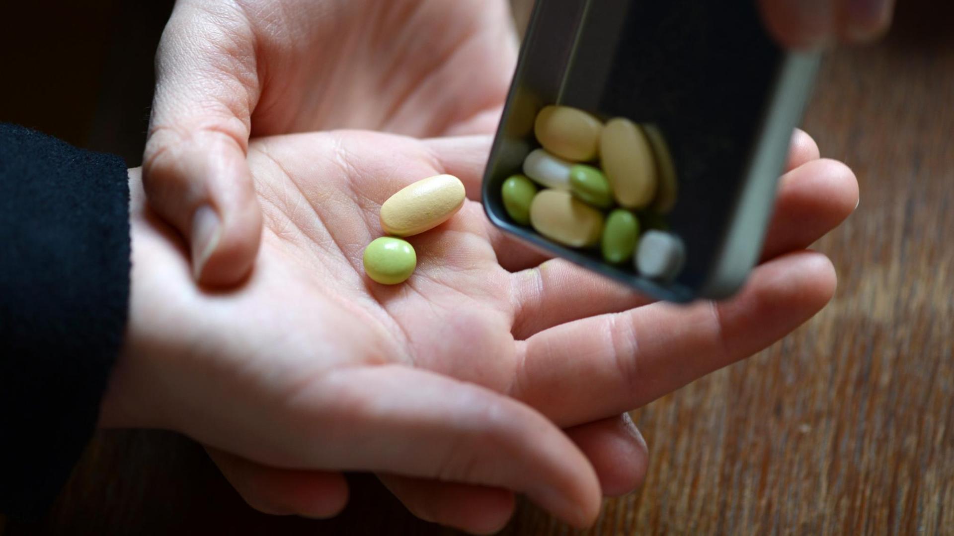 Illustration - Ein Mädchen bekommt verschiedene Tabletten in die Hand geschüttet, aufgenommen am 19.02.2014 in Berlin. Foto: Jens Kalaene/dpa | Verwendung weltweit Illustration - Ein Mädchen bekommt verschiedene Tabletten in die Hand geschüttet, aufgenommen am 19.02.2014 in Berlin. Foto: Jens Kalaene/dpa | Verwendung weltweit