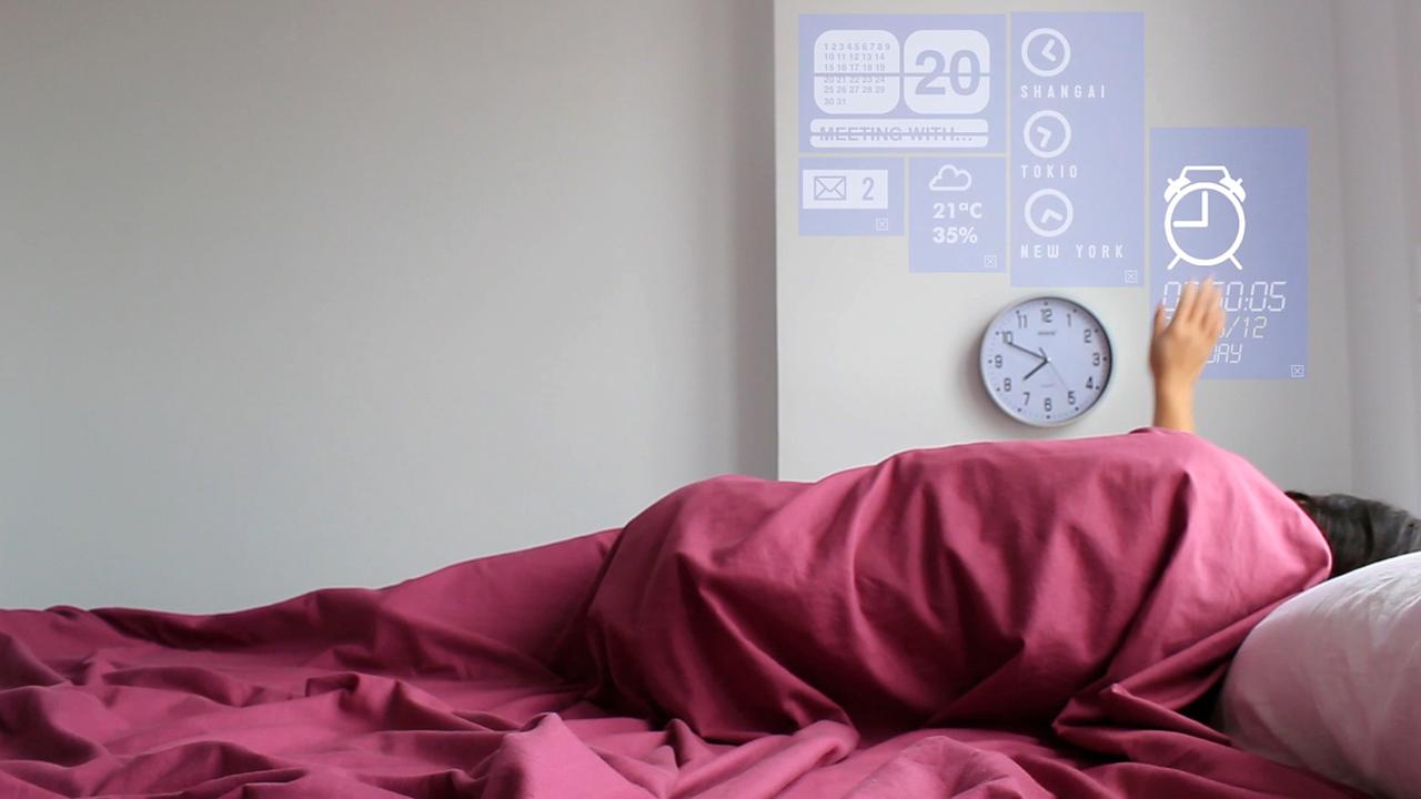 Eine Frau liegt in einem Bett und verändert mit einer Handbewegung das Licht. Die Technik wird in dem Prototyp eines Smart Home in Fuenterrabia in Spanien. Eine Frau liegt in einem Bett und verändert mit einer Handbewegung das Licht. Die Technik wird in dem Prototyp eines Smart Home in Fuenterrabia in Spanien.