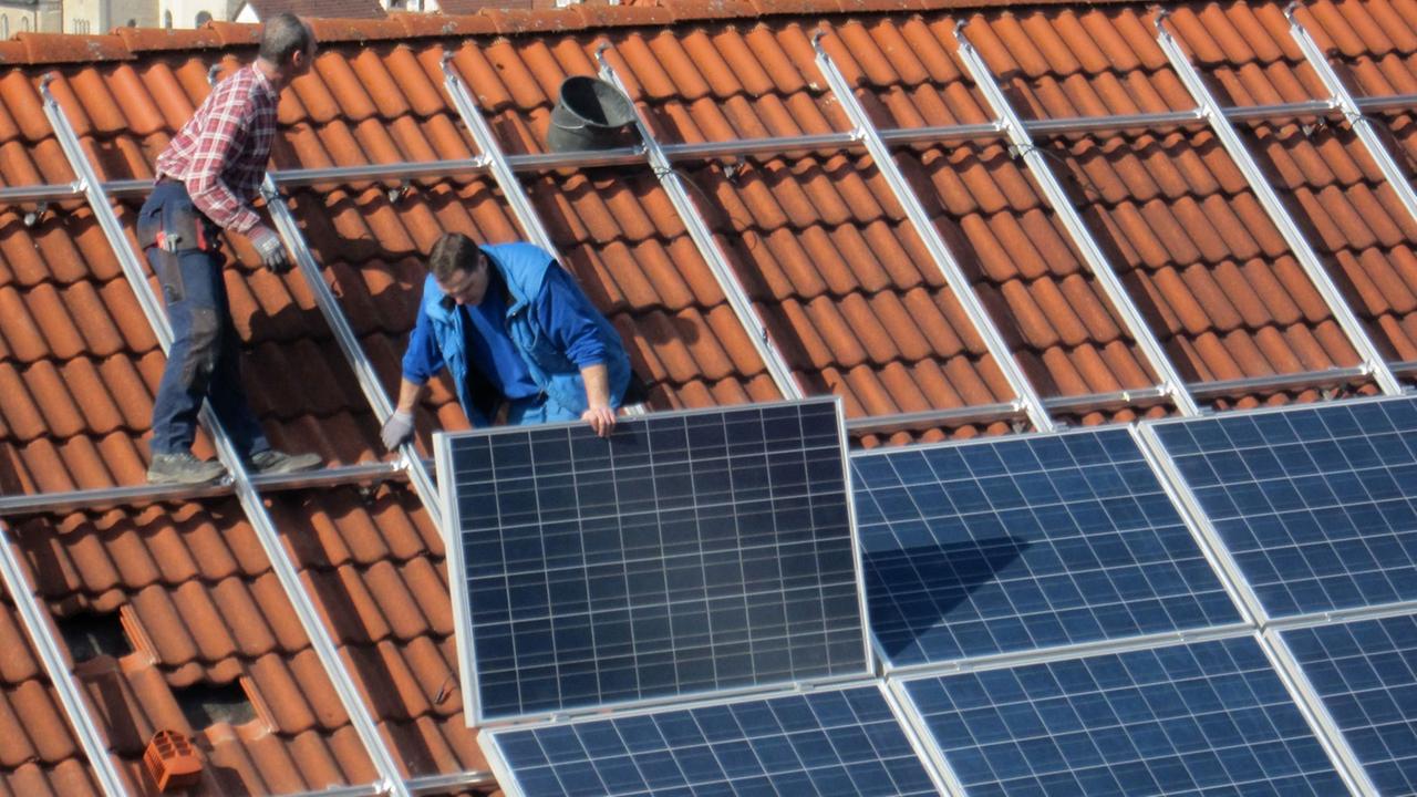 Arbeiter installieren Solarzellen auf einem Dach, aufgenommen am 06.03.2012 in Igersheim. Arbeiter installieren Solarzellen auf einem Dach, aufgenommen am 06.03.2012 in Igersheim.