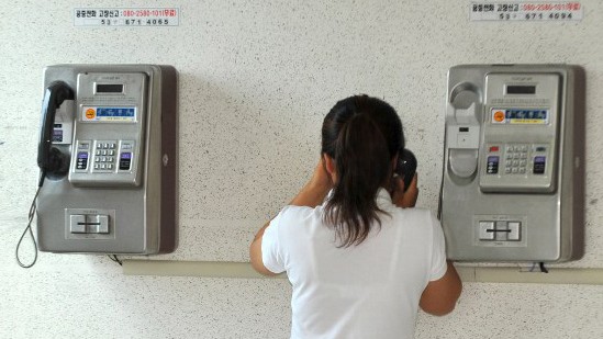 Eine junge Frau aus Nordkorea telefoniert in einem Flüchtlingslager in Südkorea Eine junge Frau aus Nordkorea telefoniert in einem Flüchtlingslager in Südkorea