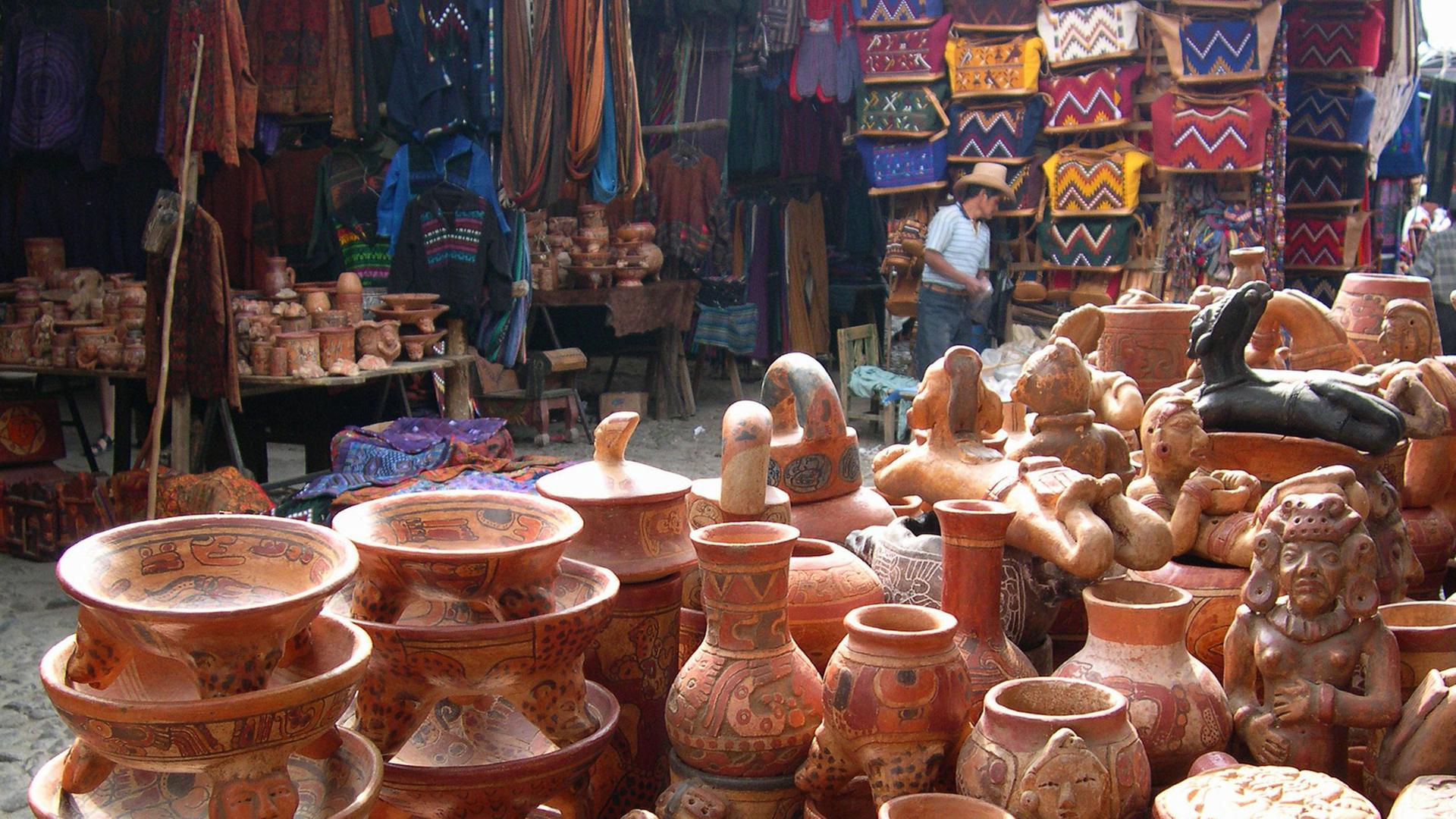 Blick auf traditionelle Tonwaren und Textilien auf einem Markt in Chichicastenango in Guatemala Blick auf traditionelle Tonwaren und Textilien auf einem Markt in Chichicastenango in Guatemala