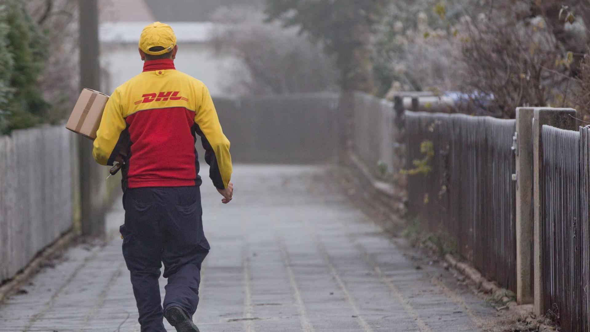 Ein DHL-Paketzusteller liefert Sendungen aus. Ein DHL-Paketzusteller liefert Sendungen aus.