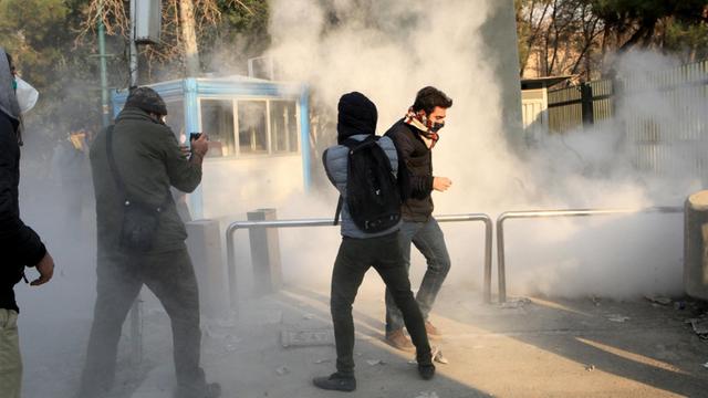Drei iranische Studenten eingehüllt in Tränengas