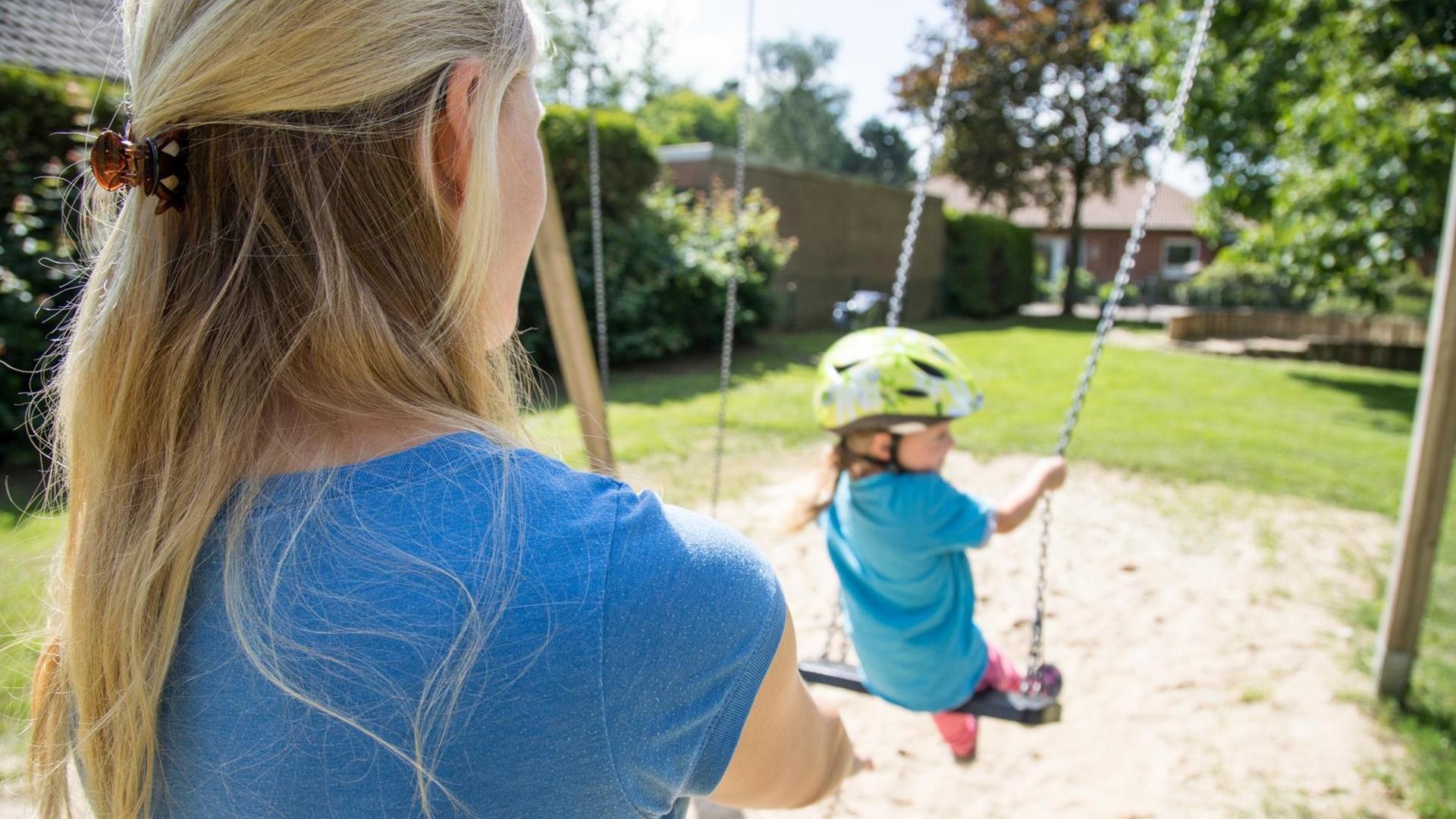 Eine Frau in Nottensdorf (Niedersachsen) mit ihrer kleinen Tochter auf dem Spielplatz (gestellte Szene). Foto: Christin Klose | dpa Themendienst | Verwendung weltweit Eine Frau in Nottensdorf (Niedersachsen) mit ihrer kleinen Tochter auf dem Spielplatz (gestellte Szene). Foto: Christin Klose | dpa Themendienst | Verwendung weltweit