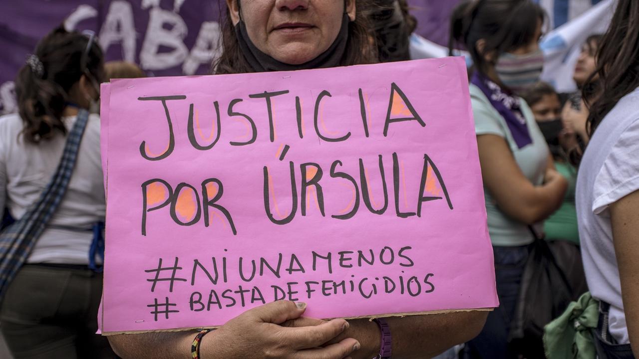 Eine Demonstrantin hält in einer Menge stehend ein pink Schild in den Händen, auf dem steht " Gerechtigkeit für Úrsula".