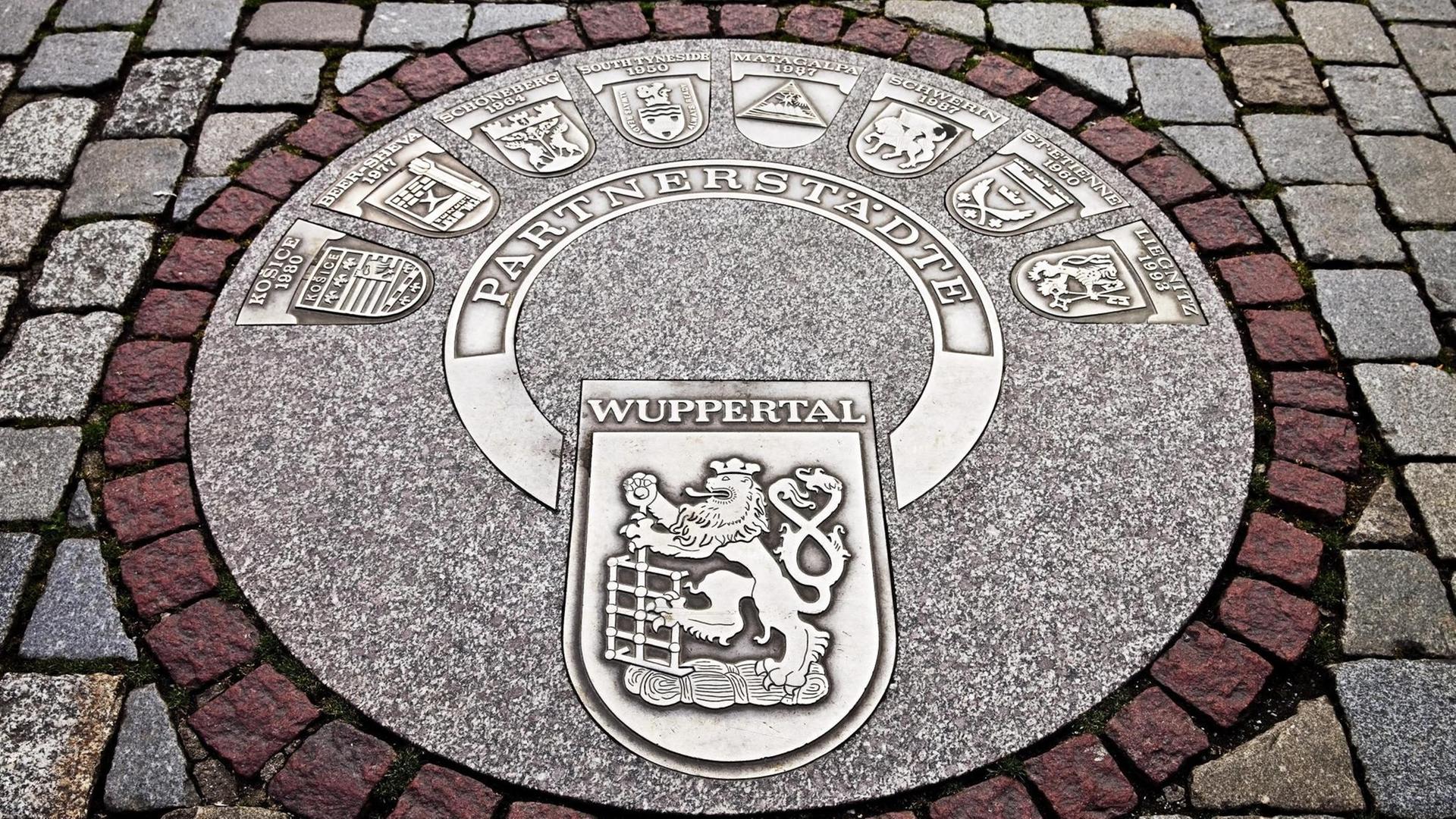 Ein Wuppertaler Kanaldeckel mit allen Partnerstädten Wuppertals Ein Wuppertaler Kanaldeckel mit allen Partnerstädten Wuppertals