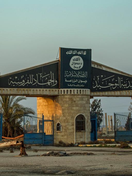 Auf einer Toreinfahrt eines zerbombten Areals in der Region um Rakka in Syrien ist das Logo der vertriebenen Terrormiliz Islamischer Staat zu sehen.