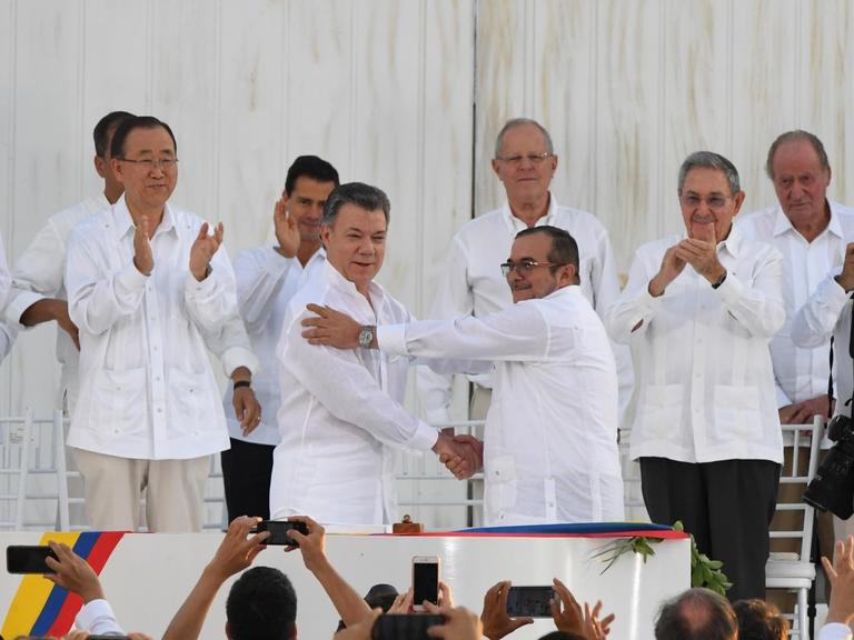 Der kolumbianische Präsident Juan Manuel Santos und der Kommandeur der FARC-Guerrilla-Organisation Timoleon Jimenez, alias Timochenko, geben sich beim Festakt in Cartagena die Hand.