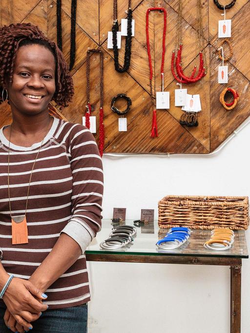 Die Buchhalterin von "Haiti Design Co-op" steht vor Produkten aus den Werkstätten. Sie fing einst als Näherin an und konnte mit dem Gehalt ihre höhere Ausbildung finanzieren.