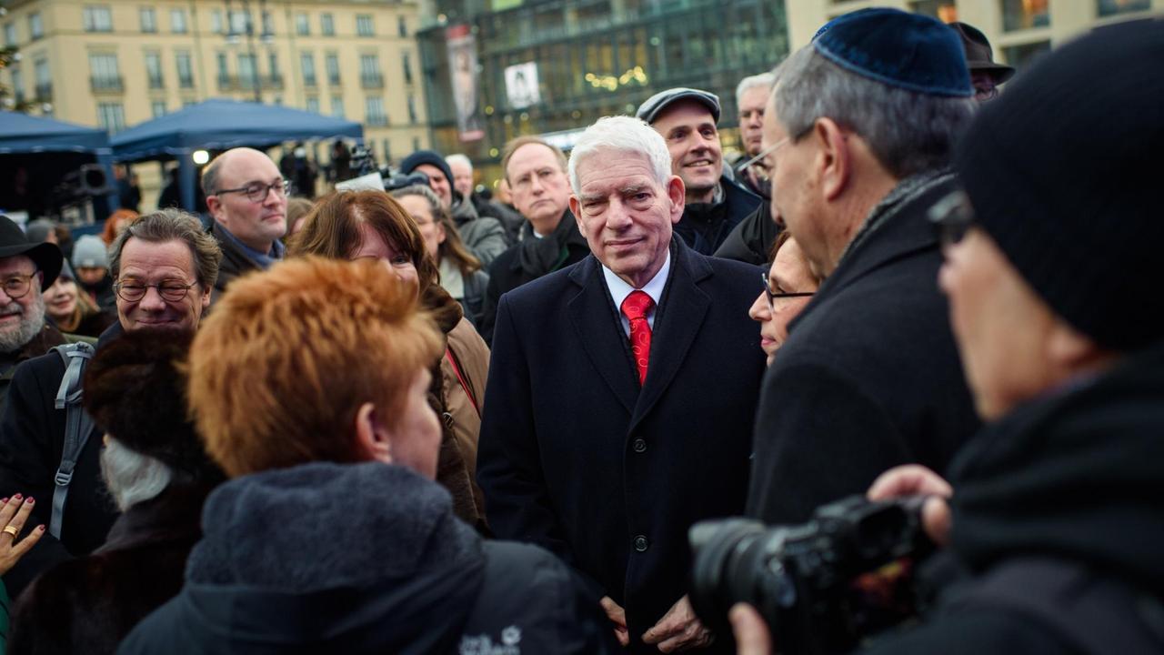 Josef Schuster, Präsident des Zentralrates der Juden in Deutschland, steht inmitten eines Pulks von Menschen.
