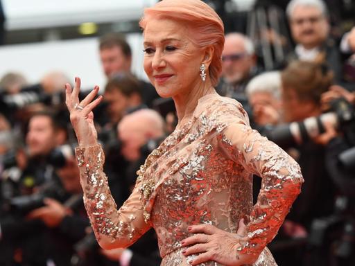 Königliche Erscheinung: Schauspielerin Helen Mirren posiert im festlichen Kleid und mit erhobener Hand vor den Fotografinnen und Fotografen bei den Filmfestspielen in Cannes 2019