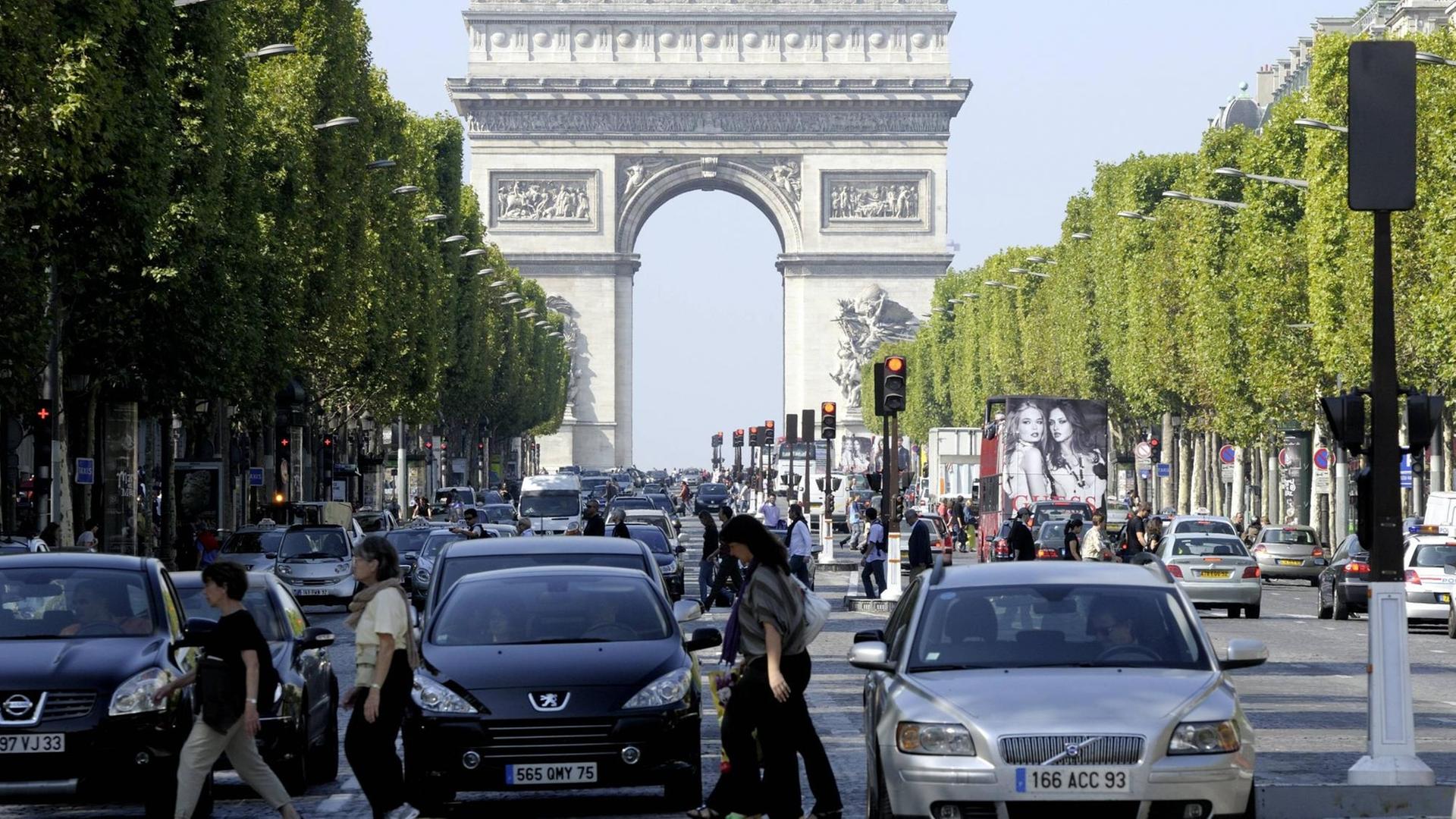 Autos sthen vor einer Kreuzung auf dem Champs d'Elysee in Paris, Im Hintergrund der Arc de Triomphe. Autos sthen vor einer Kreuzung auf dem Champs d'Elysee in Paris, Im Hintergrund der Arc de Triomphe.
