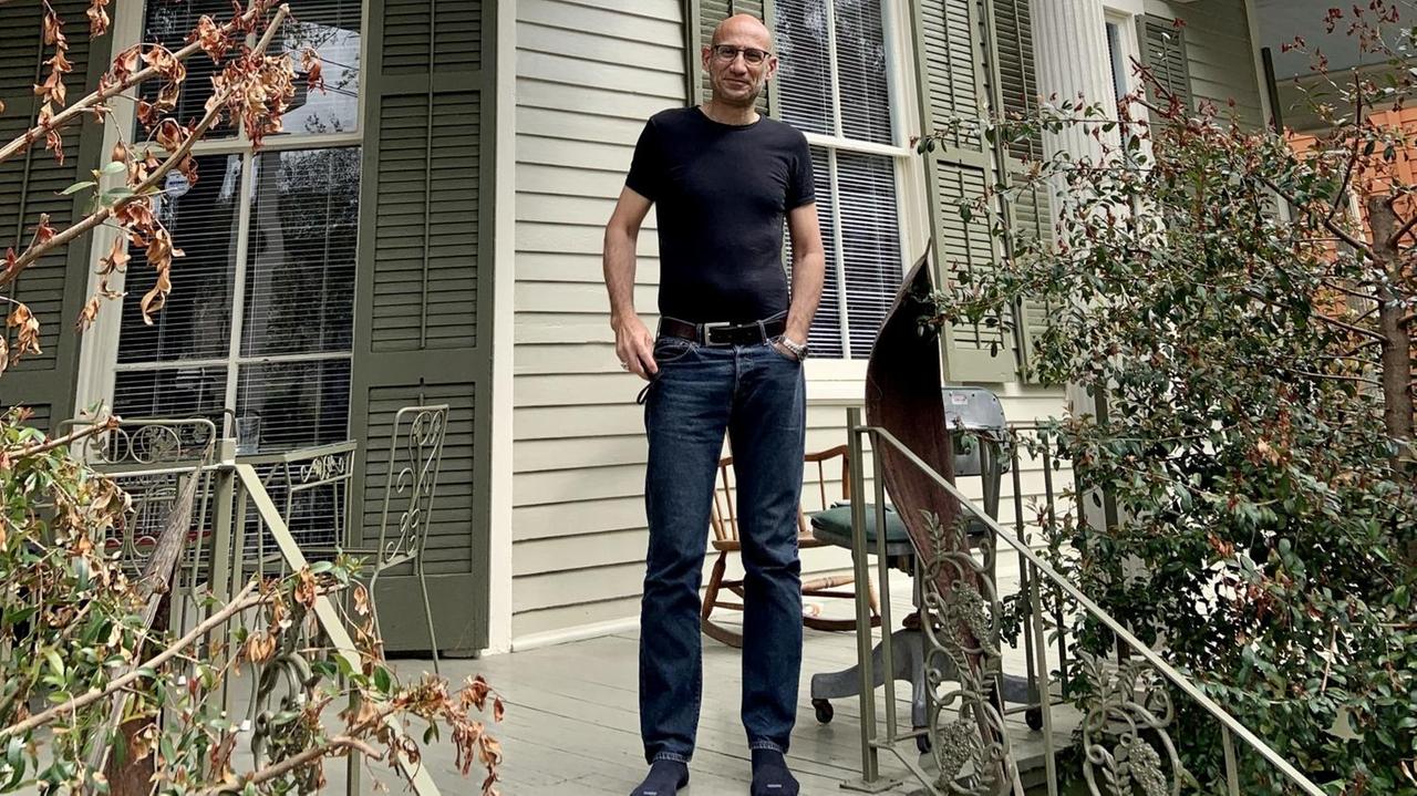 Ein Mann steht auf der Veranda eines Hauses. Ein Mann steht auf der Veranda eines Hauses.