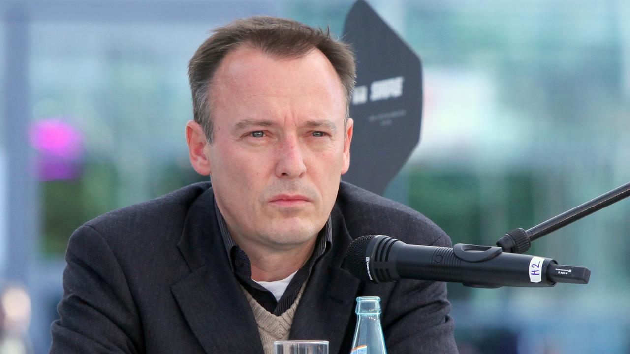 Der Autor Mirko Bonné an einem Lesepult, vor ihm ein Mikrofon und eine Flasche Wasser mit Glas. Der Autor Mirko Bonné an einem Lesepult, vor ihm ein Mikrofon und eine Flasche Wasser mit Glas.
