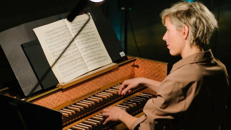 Die Musikerin sitzt spielend am Cembalo Die Musikerin sitzt spielend am Cembalo