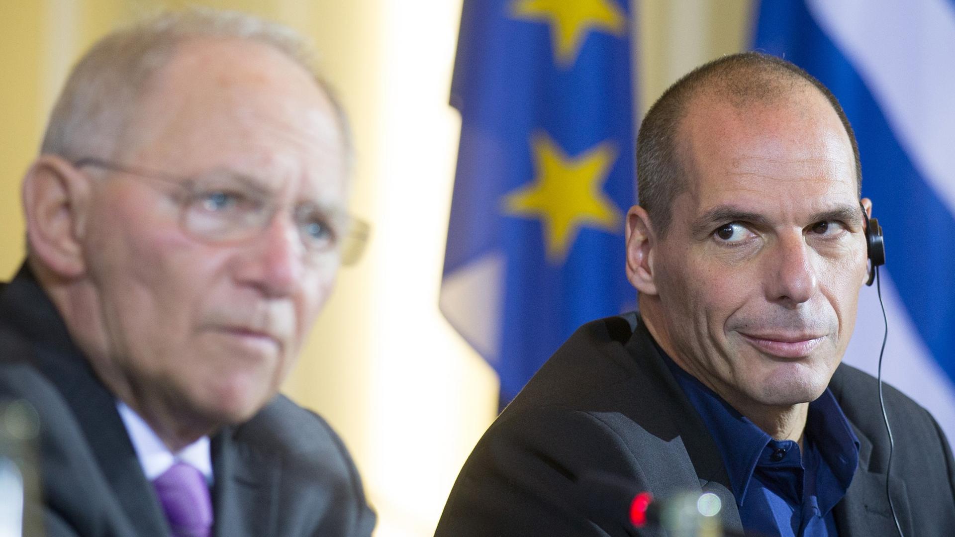 Yanis Varoufakis hört Wolfgang Schäuble zu, wie dieser auf einer gemeinsamen Pressekonferenz spricht. Yanis Varoufakis hört Wolfgang Schäuble zu, wie dieser auf einer gemeinsamen Pressekonferenz spricht.