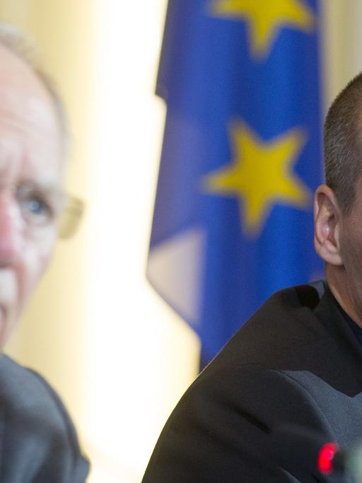 Yanis Varoufakis hört Wolfgang Schäuble zu, wie dieser auf einer gemeinsamen Pressekonferenz spricht.