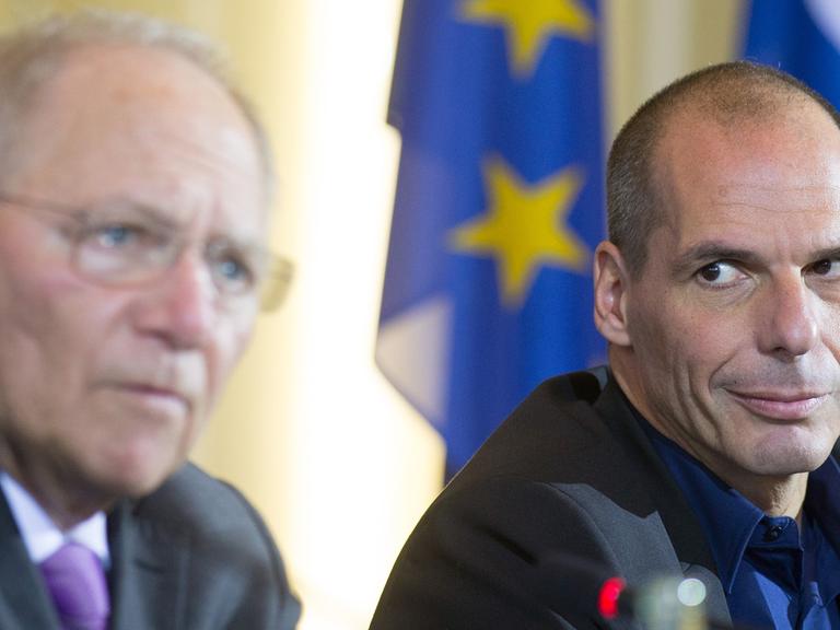 Yanis Varoufakis hört Wolfgang Schäuble zu, wie dieser auf einer gemeinsamen Pressekonferenz spricht.