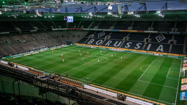 Die Mönchengladbacher und die Kölner Spieler kämpfen um den Ball. Das Spiel findet wegen des Coronavirus ohne Zuschauer als Geisterspiel statt. Die Mönchengladbacher und die Kölner Spieler kämpfen um den Ball. Das Spiel findet wegen des Coronavirus ohne Zuschauer als Geisterspiel statt.