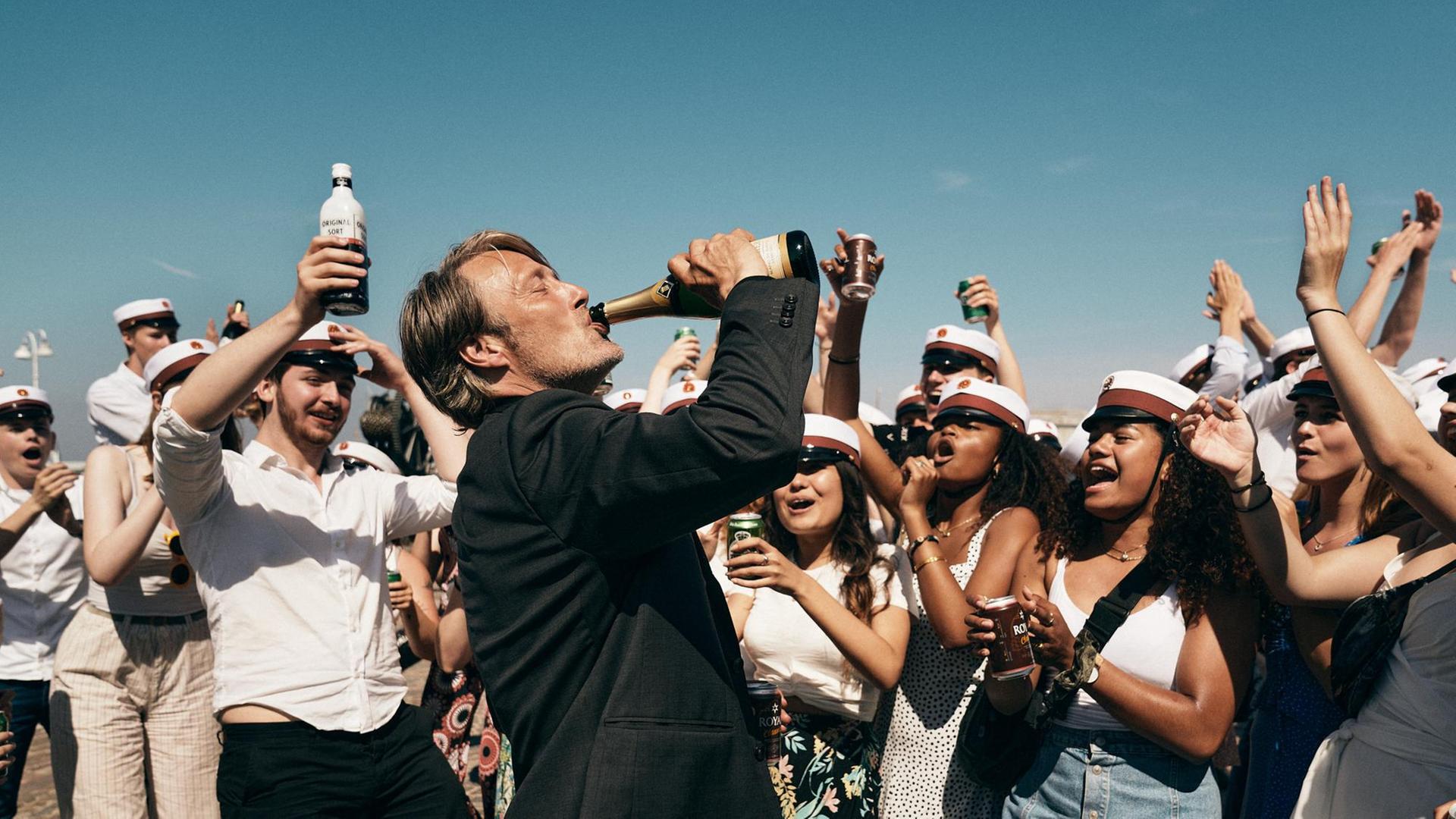 Der Schauspieler Mads Mikkelsen in einem Szenenfoto von Thomas Vinterbergs Film "Der Rausch". Mikkelsen trinkt aus einer Champagnerflasche. Der Schauspieler Mads Mikkelsen in einem Szenenfoto von Thomas Vinterbergs Film "Der Rausch". Mikkelsen trinkt aus einer Champagnerflasche.
