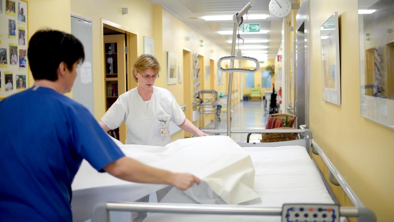Pflegerinnen bereiten ein Bett in der Palliativstation der Charité in Berlin vor Pflegerinnen bereiten ein Bett in der Palliativstation der Charité in Berlin vor