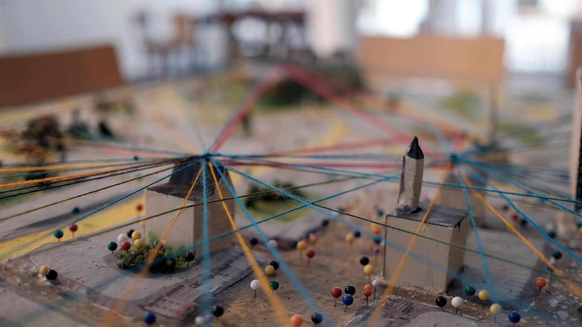 Stadtmodell, über das bunte Fäden gespannt sind. Stadtmodell, über das bunte Fäden gespannt sind.