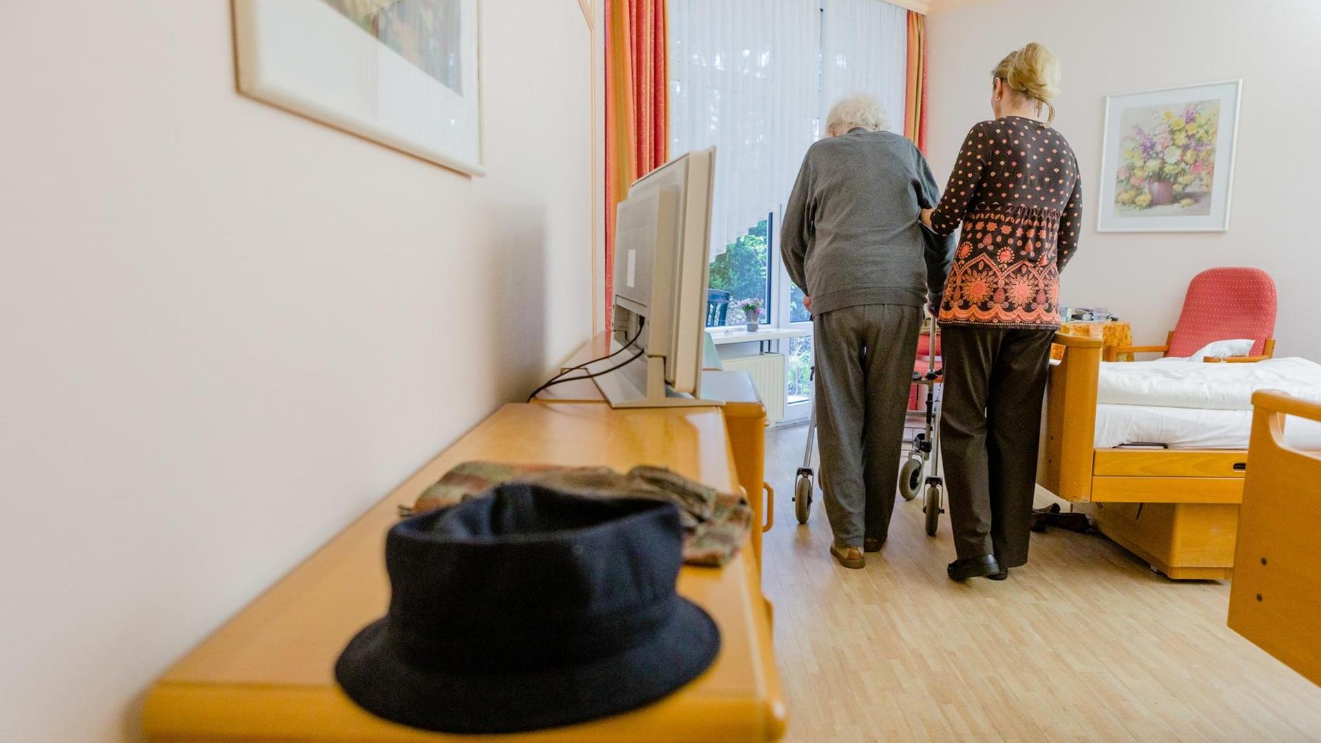 Eine Altenpflegerin begleitet am 07.11.2013 in der Seniorenresidenz Dahlke in Bad Bevensen (Niedersachsen) eine Bewohnerin in ihr Zimmer. Foto: Markus Scholz | Verwendung weltweit